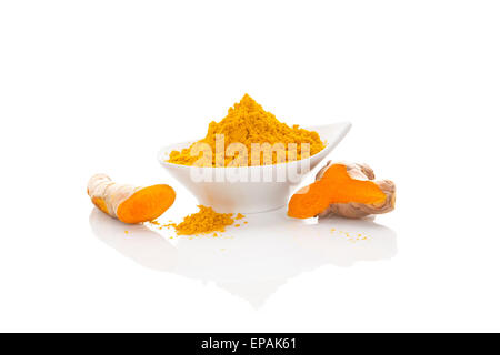 Turmeric fresh and dry ground in white bowl isolated on white background. Asian culinary spice. Ayurvedic traditional medicine. Stock Photo