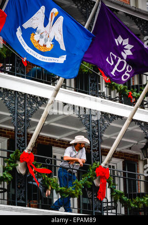 Man with cowboy hat and jeans looks over Bourbon Street from Four Points by Sheraton hotel balcony, New Orleans LA Stock Photo