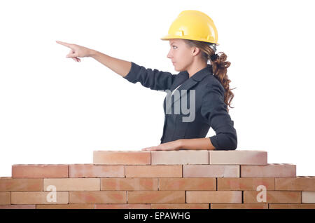 Young female builder near brick wall Stock Photo