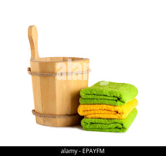 Wooden bucket with ladle for the sauna and stack of clean towels Stock Photo