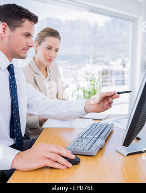 Smartly dressed colleagues using computer Stock Photo