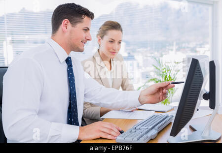 Smartly dressed colleagues using computer Stock Photo