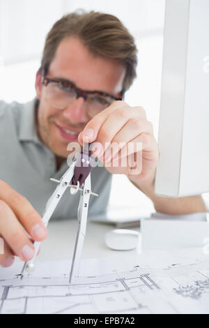 Concentrated man using compass on design Stock Photo