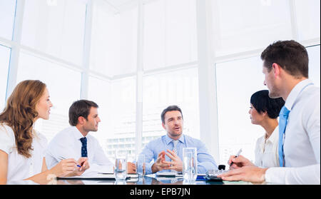 Executives sitting around conference table Stock Photo