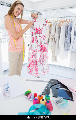 Female fashion designer working on floral dress at studio Stock Photo