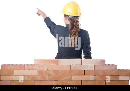 Young female builder near brick wall Stock Photo