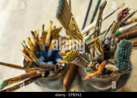 Container kit of assorted and stained old artist paintbrushes Stock Photo