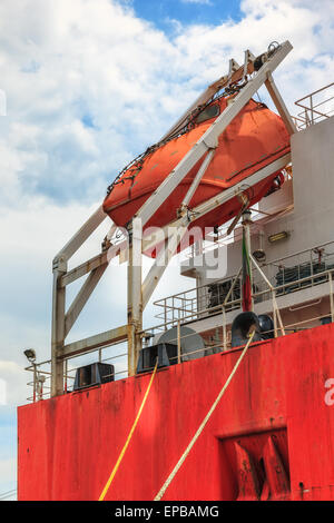 A lifeboat on the rear of a cargo ship. Stock Photo