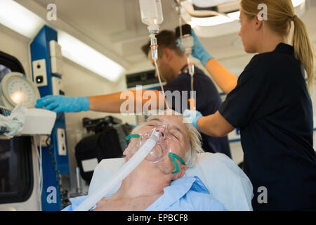 Unconscious patient with oxygen mask in ambulance Stock Photo