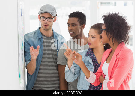 Artists in discussion in front of whiteboard Stock Photo