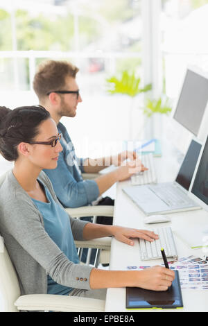 Team of young designers working at desk Stock Photo