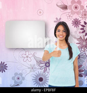 Composite image of happy brunette giving thumbs up with speech bubble Stock Photo