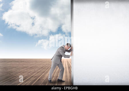 Composite image of businessman pushing away scene Stock Photo