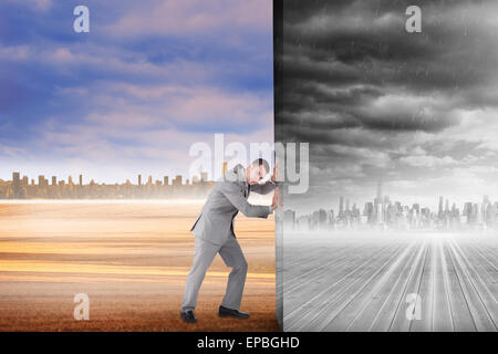 Composite image of businessman pushing away scene Stock Photo