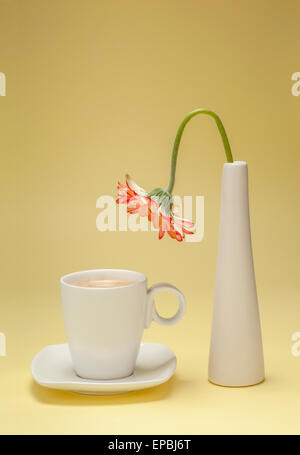 Thirsty flower bending over a cup of coffee Stock Photo