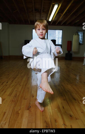Boy in karate class demonstrating kick Stock Photo