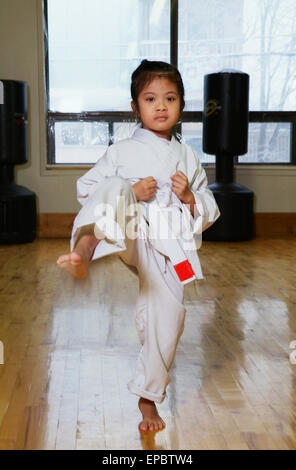 Girl in karate class demonstrating kick Stock Photo