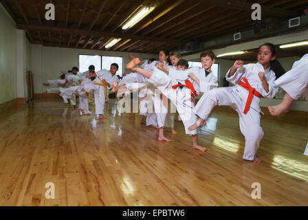 Kids in karate class demonstrating kicks Stock Photo