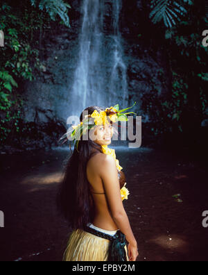 Tahitian woman wearing grass skirt bathing in waterfall; Tahiti Stock Photo