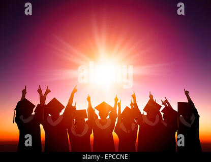silhouette of Students Celebrating Graduation watching the sunlight Stock Photo