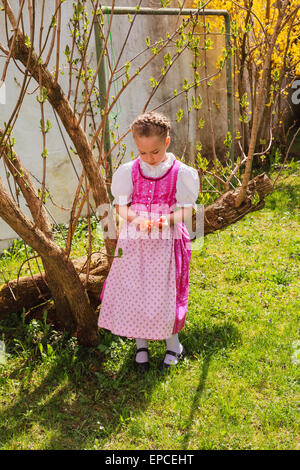 Girl in the dirndl is bored with coloured ones wobble in the hand Stock Photo