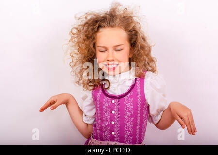 Small Bavarian girl in the dirndl in pose Stock Photo