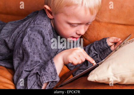 Child with Digital tablet. The Boy play and learn when he is using the tablet Stock Photo
