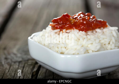 Bowl full of rice and tomato sauce over wooden background Stock Photo