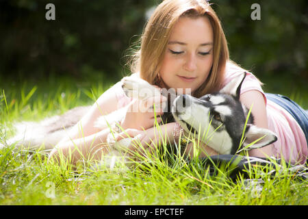 Young woman and her husky in the forest Stock Photo