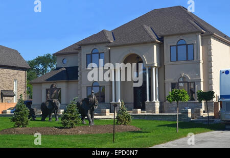 A beautiful new big house from the front with the front yard and the nice decoration with three bronze elephants and some small Stock Photo