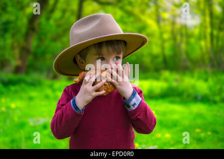 adorable little boy eating a croissant Stock Photo