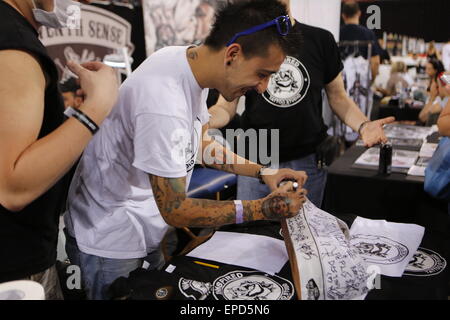 Athens, Greece. 16th May, 2015. A tattoo artist signs a large shoe of a fan. Greek and international tattoo artists came to Athens for the 9th International Athens Tattoo Convention, showing off their talents in competitions and while tattooing visitors. © Michael Debets/Pacific Press/Alamy Live News Stock Photo