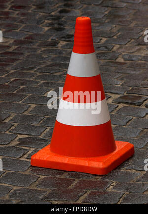 road cone standing on wet pavement Stock Photo