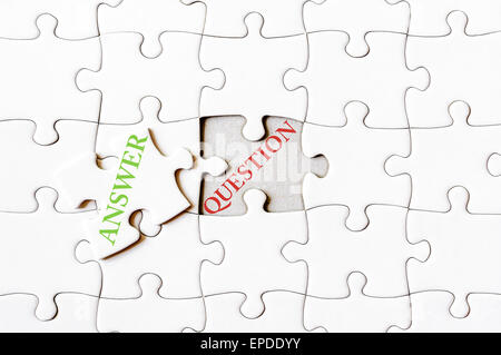 Missing jigsaw puzzle piece with word ANSWER, as solution for QUESTION. Business concept image for completing the final puzzle piece. Stock Photo