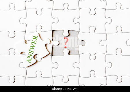 Missing jigsaw puzzle piece with word ANSWER, covering question mark. Business concept image for completing the final puzzle piece. Stock Photo