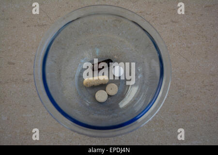 Overhead view of daily vitamins in a glass dish Stock Photo