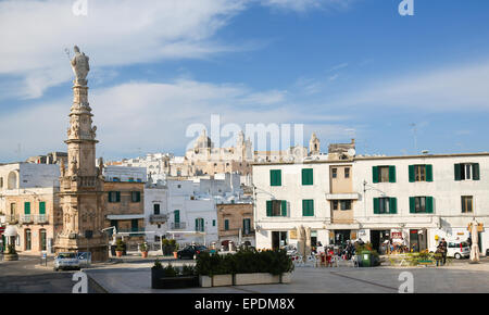 OSTUNI, ITALY - MARCH 14, 2015: View on the Statue of San Oronzo and the Old Town of Ostuni, Puglia, Italy. Stock Photo