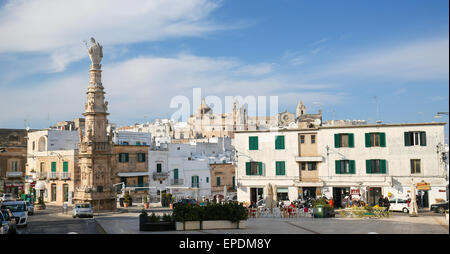 OSTUNI, ITALY - MARCH 14, 2015: View on the Statue of San Oronzo and the Old Town of Ostuni, Puglia, Italy. Stock Photo
