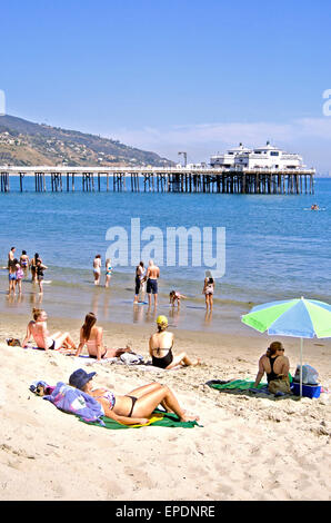 sunbathers relax on sandy Malibu California beach Stock Photo