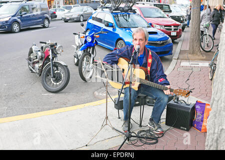 A street musician playing folk songs in downtown Bend, Oregon, during a spring evening Stock Photo