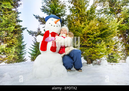 Child Hug Snowman Child Play With Snowman In Snow Field Kids Winter child-hug-snowman-child-play-with-snowman-in-snow-field-kids-winter