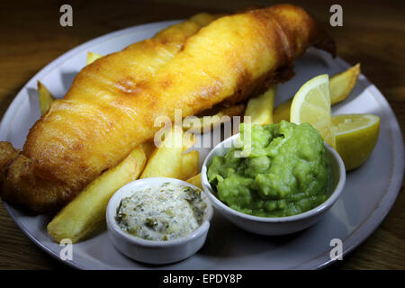 Fish and chips served with mushy peas and tartar sauce at St Mary's Inn near Stannington in Northumberland. Stock Photo