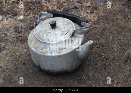 Old aluminum kettle on a dirty background. Stock Photo