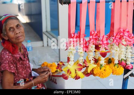 old woman Thailand selling flower garlands BANGKOK, THAILAND - Thai woman sells Buddhist flowers on the street Stock Photo