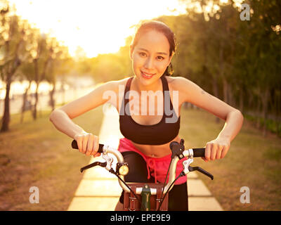 young woman riding bike in nature Stock Photo