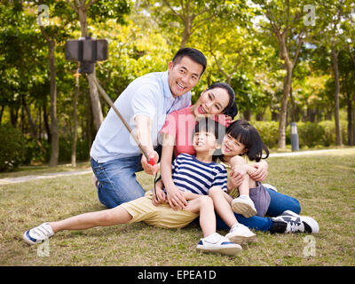 happy asian family taking a selfie with selfie stick Stock Photo