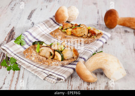 Delicious fresh bruschetta with seasonal vegetable and mushrooms on white wooden background. Culinary traditional eating. Stock Photo