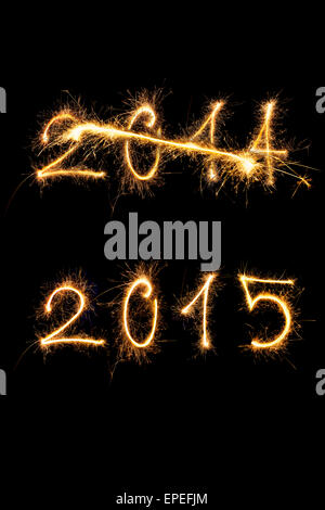 Strikethrough 2014 and 2015 digits made of sparkling light isolated on black background. Old year going, new year comming. Stock Photo