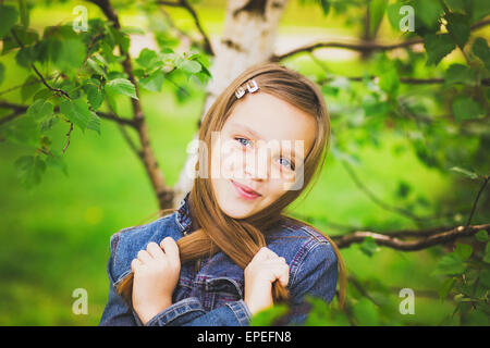 portrait of pretty teen girl smiling and looking at camera. child in green park. close up of cute 12 years old girl Stock Photo