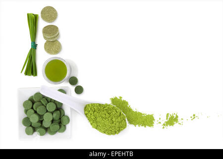 Green superfood. Spirulina, chlorella and wheat grass ground powder, effervescent tablets, grass blades isolated on white Stock Photo